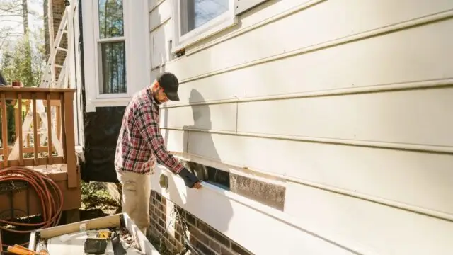 Construction worker repairing a colonial style house siding
